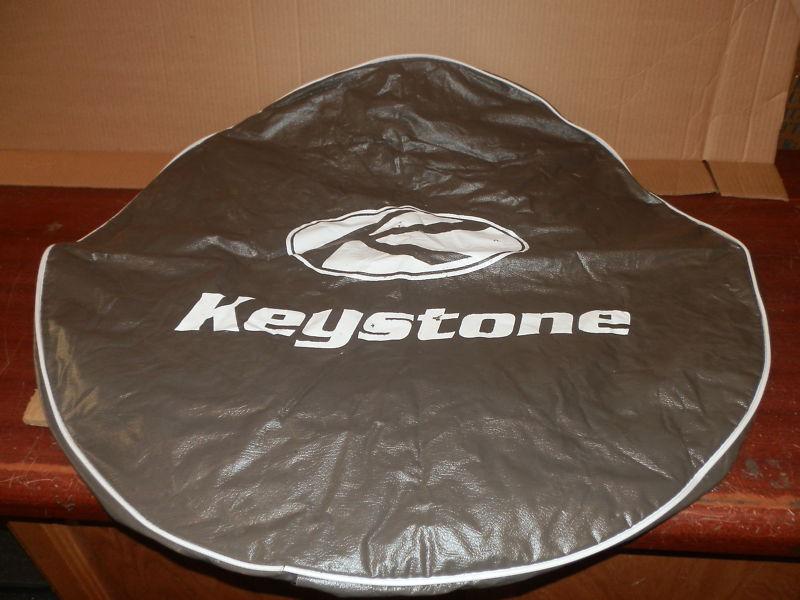 Rv grey tire cover says keystone in the middle 